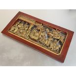 A Chinese carved giltwood panel, elaborately pierced and modelled with deities, musicians and
