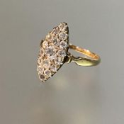A diamond cluster ring, c. 1900, the navette setting centred by an old-cut stone within a band of