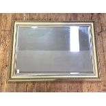 A gilt framed wall hanging mirror, the cavetto moulded frame enclosing a bevelled plate, 105cm x