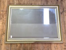 A gilt framed wall hanging mirror, the cavetto moulded frame enclosing a bevelled plate, 105cm x