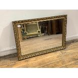 A floral moulded composition gilt framed wall hanging mirror, 87cm x 62cm