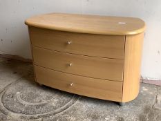 A modern beech chest of oval outline, fitted with three drawers, raised on tapered supports,