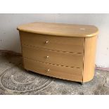 A modern beech chest of oval outline, fitted with three drawers, raised on tapered supports,