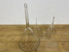 A group of four 19thc wine funnels, with rifled interiors, some chips and losses (largest: 27cm)