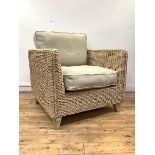 A wicker veranda chair of square form, with upholstered squab cushions, raised on square tapered
