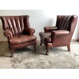 A Pair of George III style barrel back wing armchairs, upholstered in studded ox blood leather,