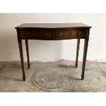 A cross banded mahogany serpentine serving table in the Regency taste, with a drawer and a fitted