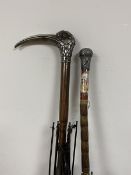 A group of two early 20thc umbrellas, one has a birds head handle with long beak marked with a T and