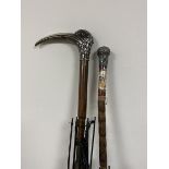 A group of two early 20thc umbrellas, one has a birds head handle with long beak marked with a T and