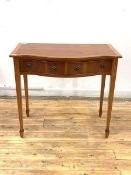 A yew wood hall table of serpentine outline, the cross banded top over two frieze drawers, raised on