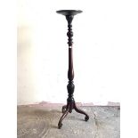 A Georgian style mahogany torchere, the circular dished top over turned and leaf carved column