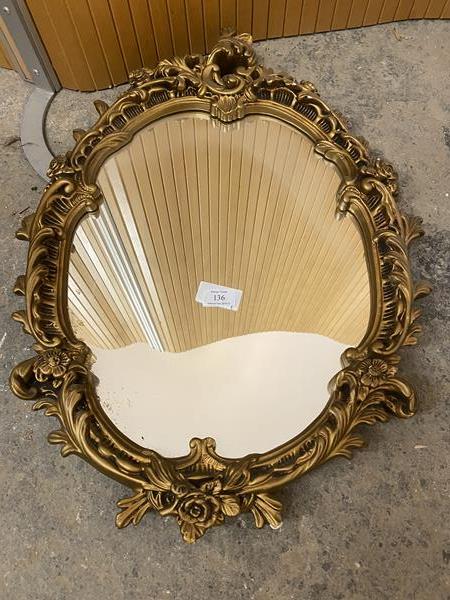 A modern rococo style wall mirror, the oval glass within a gilt frame (65cm x 50cm)