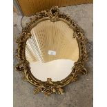 A modern rococo style wall mirror, the oval glass within a gilt frame (65cm x 50cm)