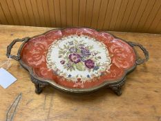 A ceramic tray with floral and scrolling vine decoration in a brass mount with two handles to