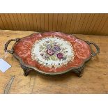 A ceramic tray with floral and scrolling vine decoration in a brass mount with two handles to