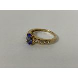 A 9ct gold ring with central oval cut stone flanked by four clear stones to each shoulder (P) (2.