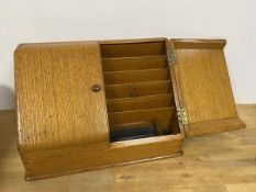 A 1930s/40s oak stationery box, the slope front with two doors and fitted interior (24cm x 36cm x