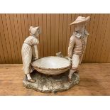A Royal Worcester figural group of man and woman in hats carrying large basket, chips to gentleman's