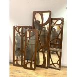 A group of four wall hanging mirrors of Art Nouveau design with the fret cut painted frames, largest