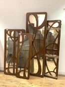 A group of four wall hanging mirrors of Art Nouveau design with the fret cut painted frames, largest