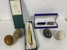 Two Waterman pens in original presentation box, a brass cricket bat (16cm) and four polished stone
