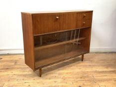 A mid century teak bookcase, the fall front enclosing correspondence shelves, with two drawers en