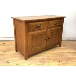 A hardwood sideboard, the moulded rectangular top over two drawers, with twin panelled doors to