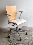 A contemporary desk chair, the laminated and white faux leather upholstered seat and arm rests