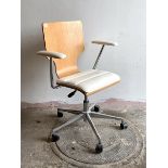 A contemporary desk chair, the laminated and white faux leather upholstered seat and arm rests