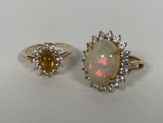 Two 9ct gold cluster rings, each with an opal cabouchon surrounded by clear stones (P) (combined: