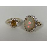 Two 9ct gold cluster rings, each with an opal cabouchon surrounded by clear stones (P) (combined: