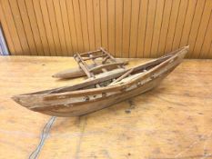 A model of an outrigger canoe measures 10x46x22cm