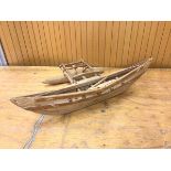 A model of an outrigger canoe measures 10x46x22cm