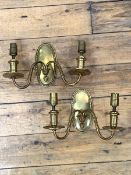 A pair of early 20th century cast brass two branch wall sconces, together with decorative shades,