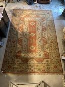 A Large Turkish hand knotted carpet in orange, pale blue and ivory, with three lozenge medallions,