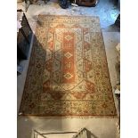 A Large Turkish hand knotted carpet in orange, pale blue and ivory, with three lozenge medallions,