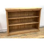 A pine floor standing bookcase, with two adjustable shelves, raised on a plinth base, W134cm, H97cm,