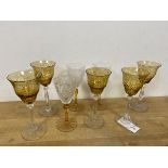 A group of eight wine glasses, some with amber coloured bowls or stems (tallest: 20cm)