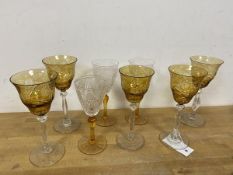 A group of eight wine glasses, some with amber coloured bowls or stems (tallest: 20cm)