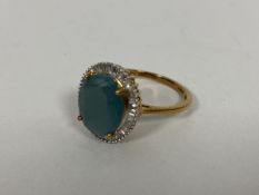 A 9ct gold dress ring set oval cut grandidierite stone within a border of diamonds (O/P) (3.36g)
