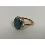 A 9ct gold dress ring set oval cut grandidierite stone within a border of diamonds (O/P) (3.36g)