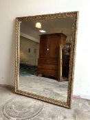 A Large wall hanging mirror, the floral moulded distressed gilt frame enclosing a rectangular mirror