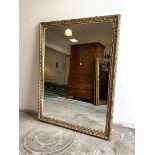 A Large wall hanging mirror, the floral moulded distressed gilt frame enclosing a rectangular mirror
