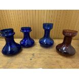 A group of four glass vases, three in cobalt blue measuring 18cm high, other amethyst (4)