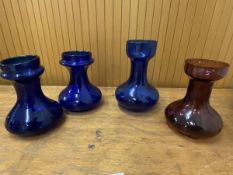 A group of four glass vases, three in cobalt blue measuring 18cm high, other amethyst (4)