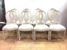 A Set of eight cream painted Gustavian style dining chairs, floral carved crest rail over oval