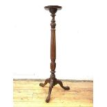 A Georgian style mahogany torchere, early 20th century, the circular dished top on a turned and