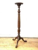 A Georgian style mahogany torchere, early 20th century, the circular dished top on a turned and