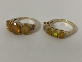 A 10ct gold ring with three oval cut opals flanked by chip diamonds to shoulders (O) and another