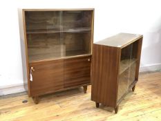 A Vintage mid century teak bookcase, with two sliding glass doors enclosing a shelf, over two